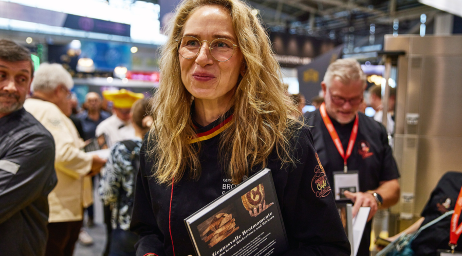 Blonde Frau mit Brille trägt das Buch Genussvolle Brotmomente