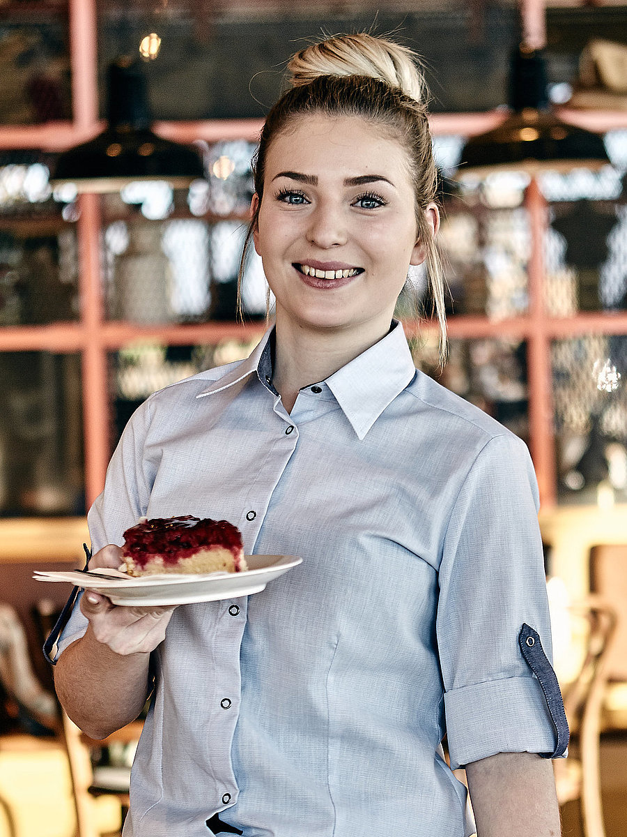 Bäckereifachverkäuferin hält Kuchen