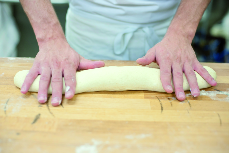 Bäcker rollt Teig