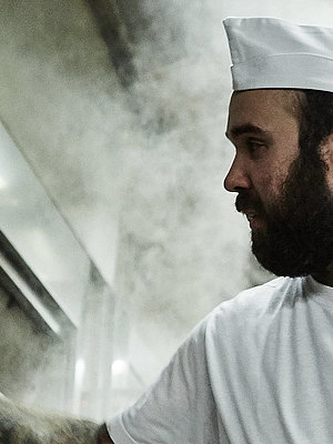 Bäcker prüft etwas am Ofen