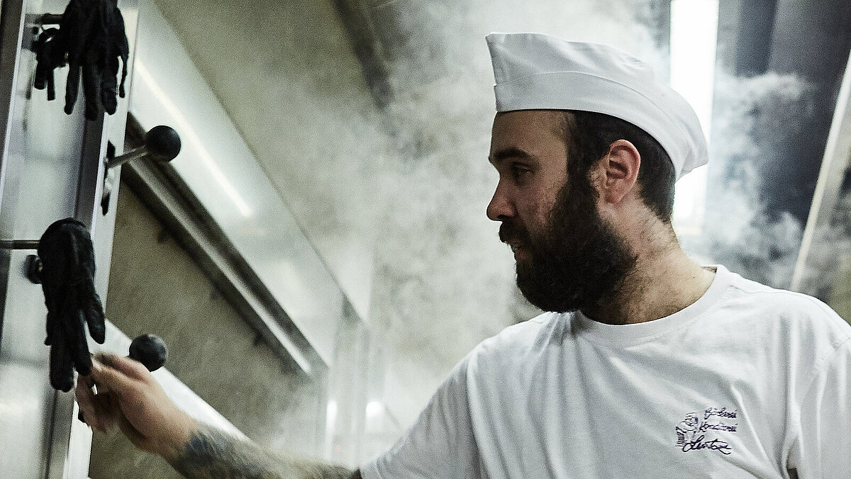 Bäcker prüft etwas am Ofen