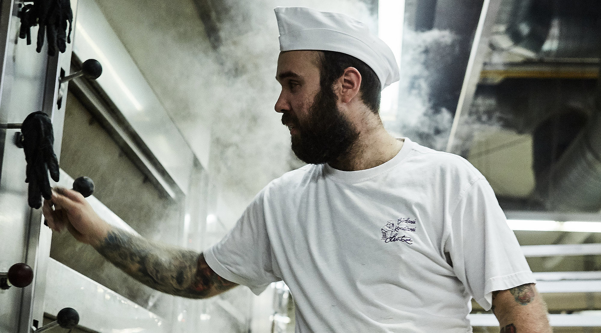 Bäcker prüft etwas am Ofen