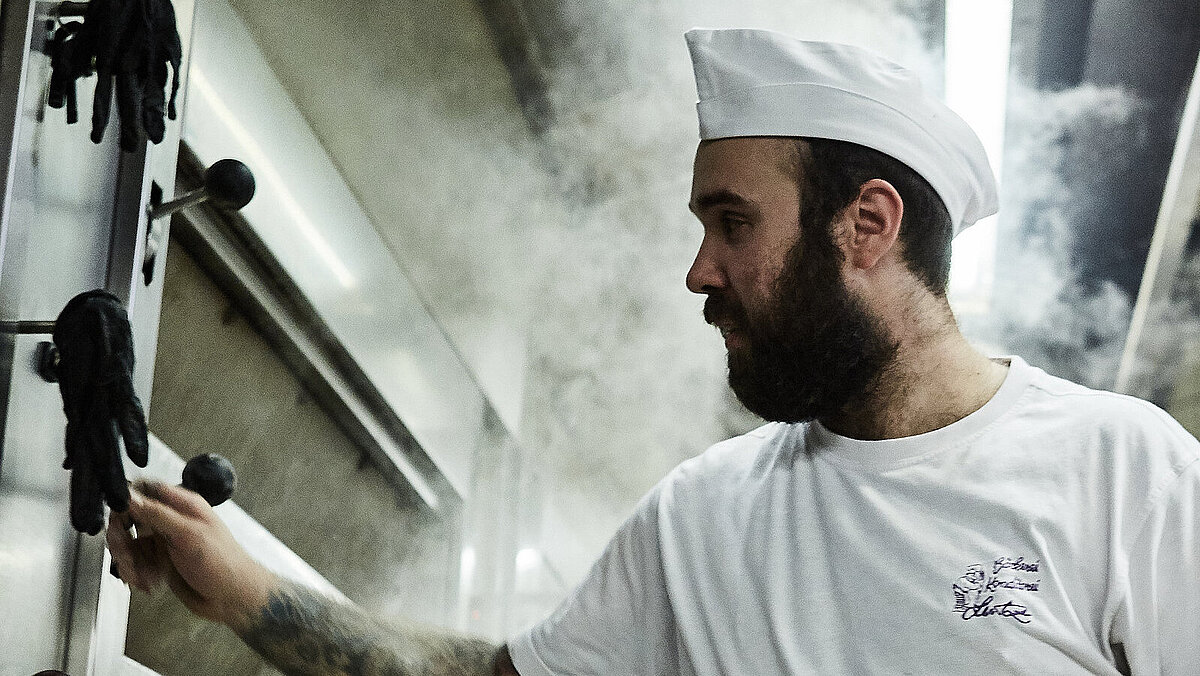 Bäcker prüft etwas am Ofen