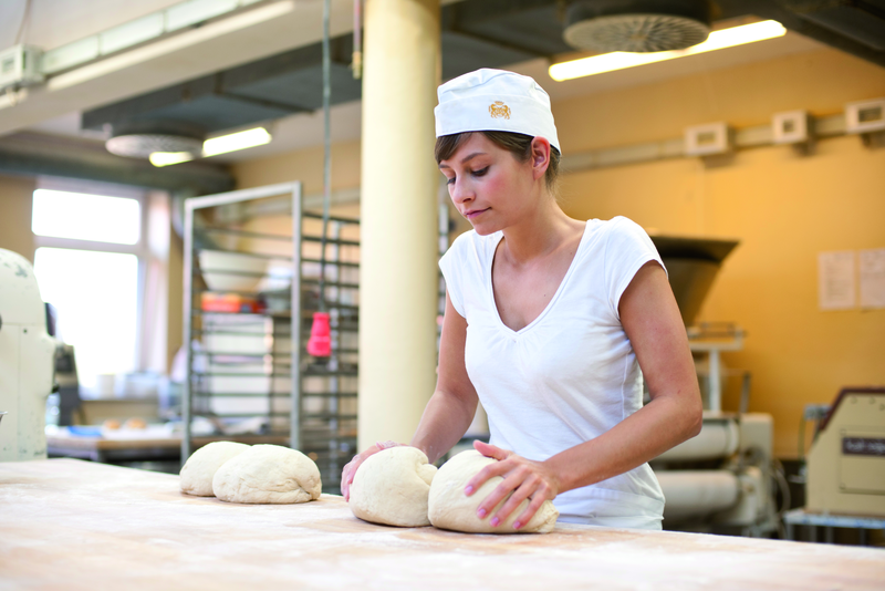 Bäckerauszubildende knetet Teig