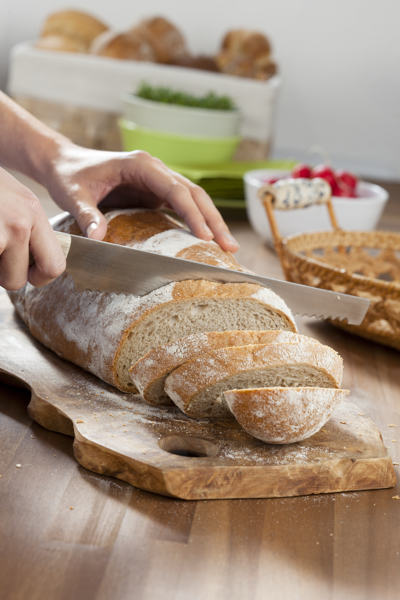 Brot schneiden auf einem Holzbrett
