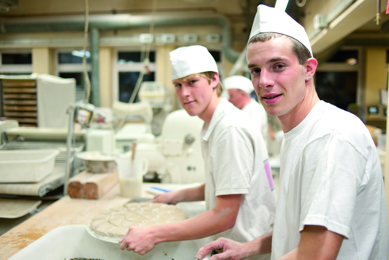 Bäckergesellen mit Brötchenteig