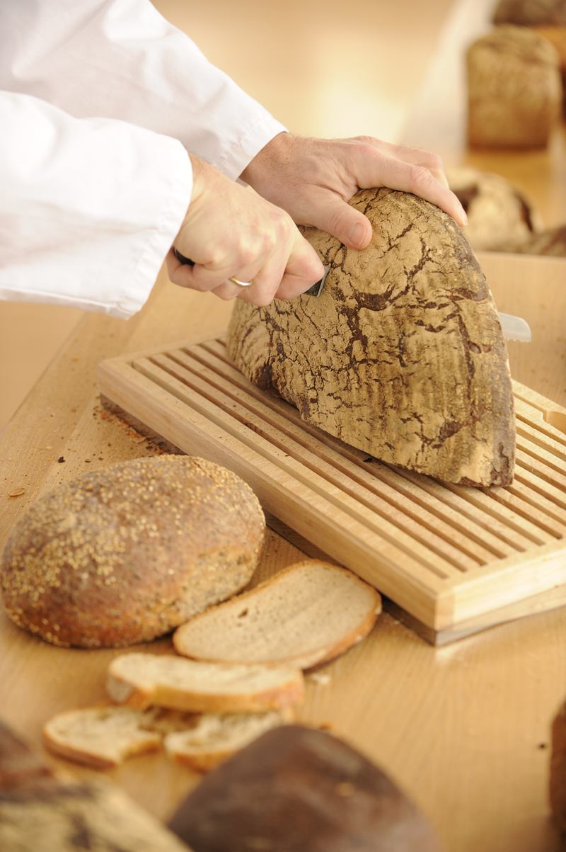 Bäcker schneidet Rundbrot