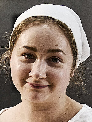 Bäckerin beim Teig kneten