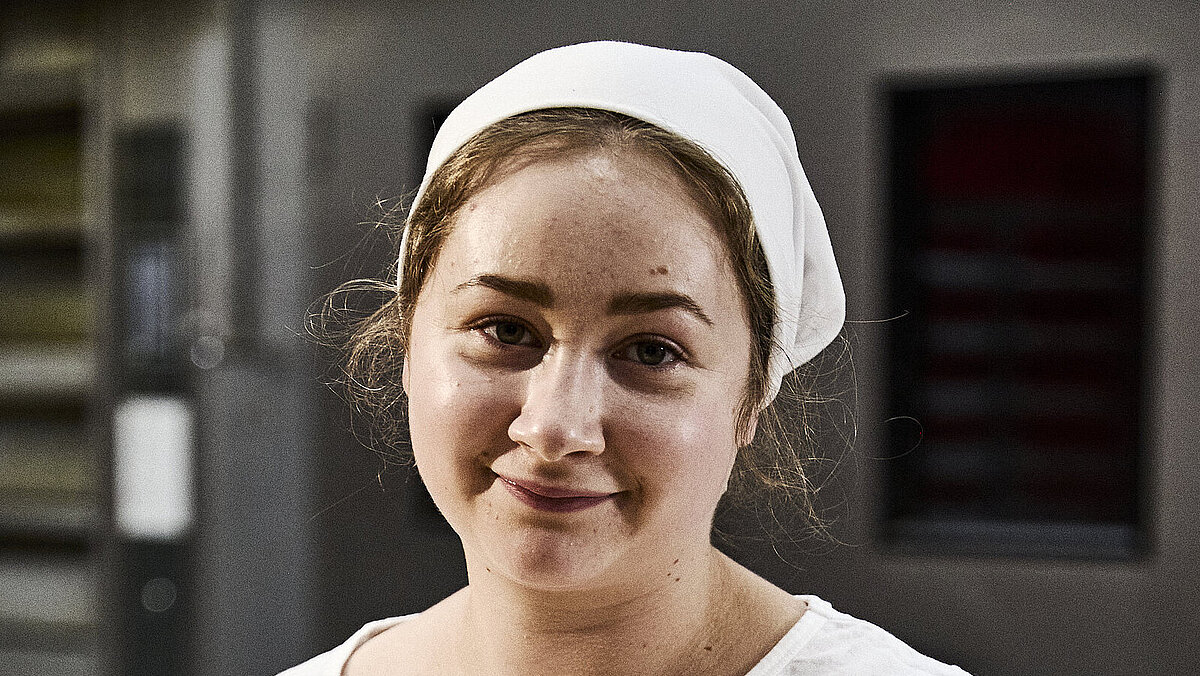 Bäckerin beim Teig kneten