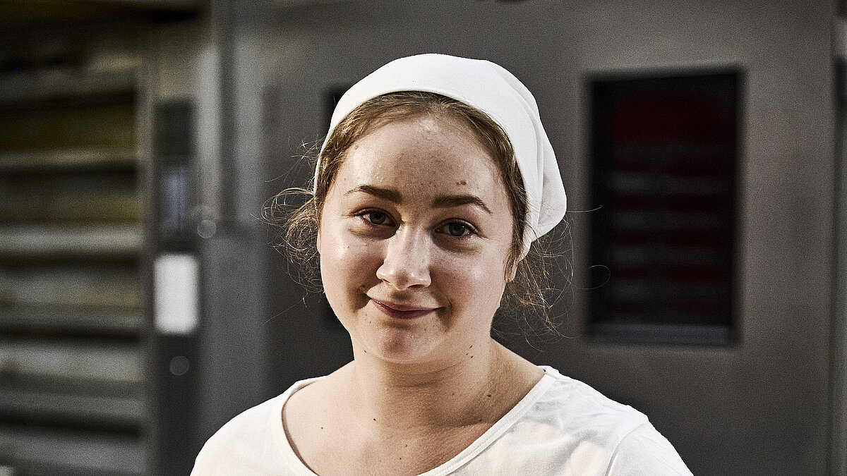 Bäckerin beim Teig kneten