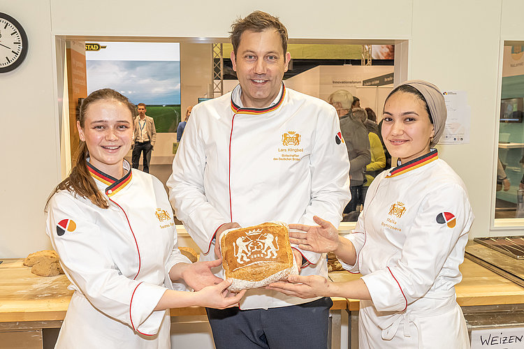 Bäcker halten Brot in die Kamera