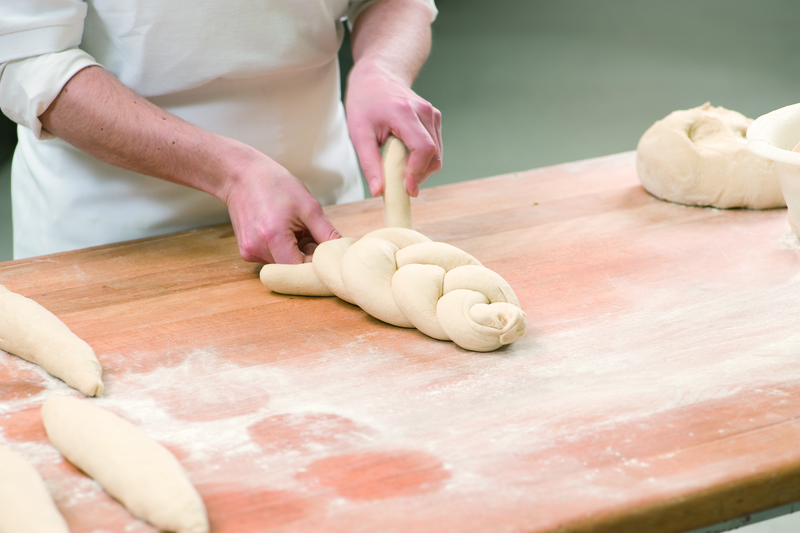 Bäcker formt Teig zu einem Zopf