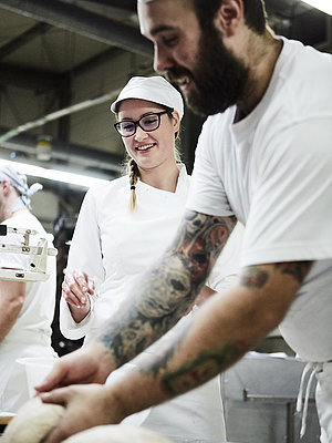 Bäcker nimmt ein Stück Teig in die Hand