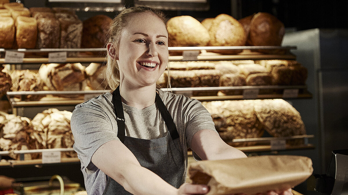 Bäckereifachverkäuferin bedient Kunden