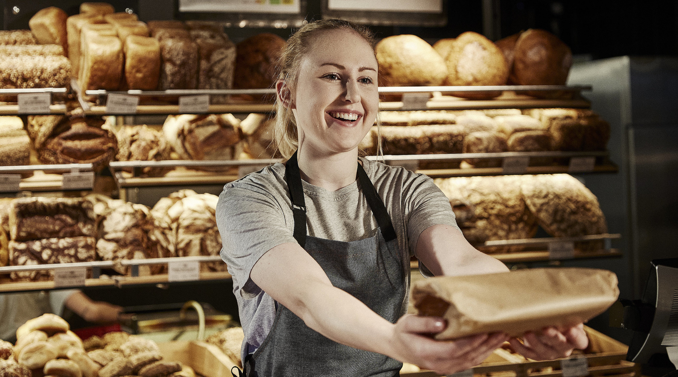 Bäckereifachverkäuferin bedient Kunden