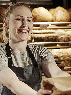 Bäckereifachverkäuferin bedient Kunden